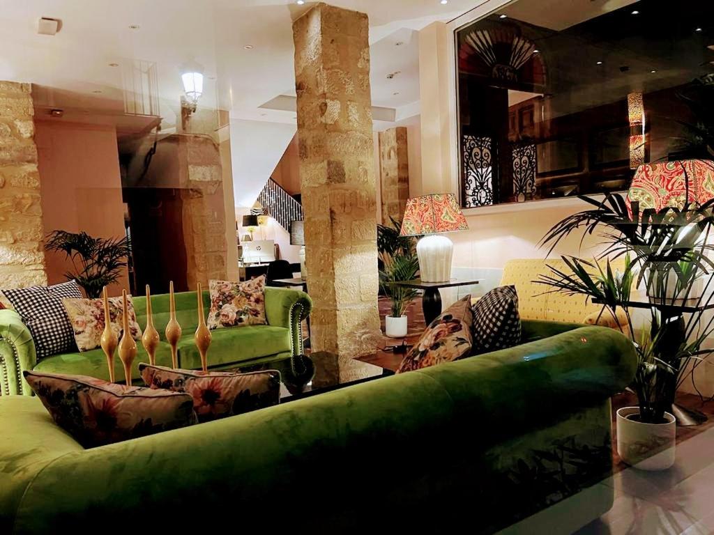 巴埃萨Hotel Carmen Boutique的客厅配有绿色沙发和椅子