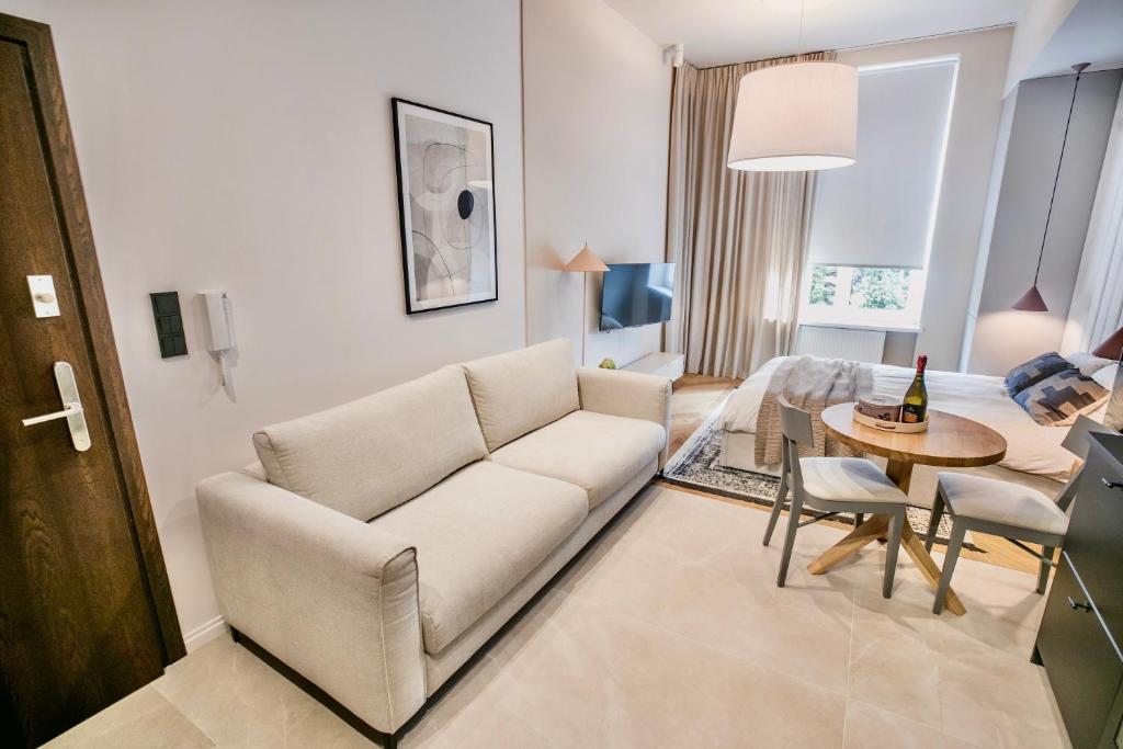 托伦Apartament Migdałowy的客厅配有白色的沙发和桌子