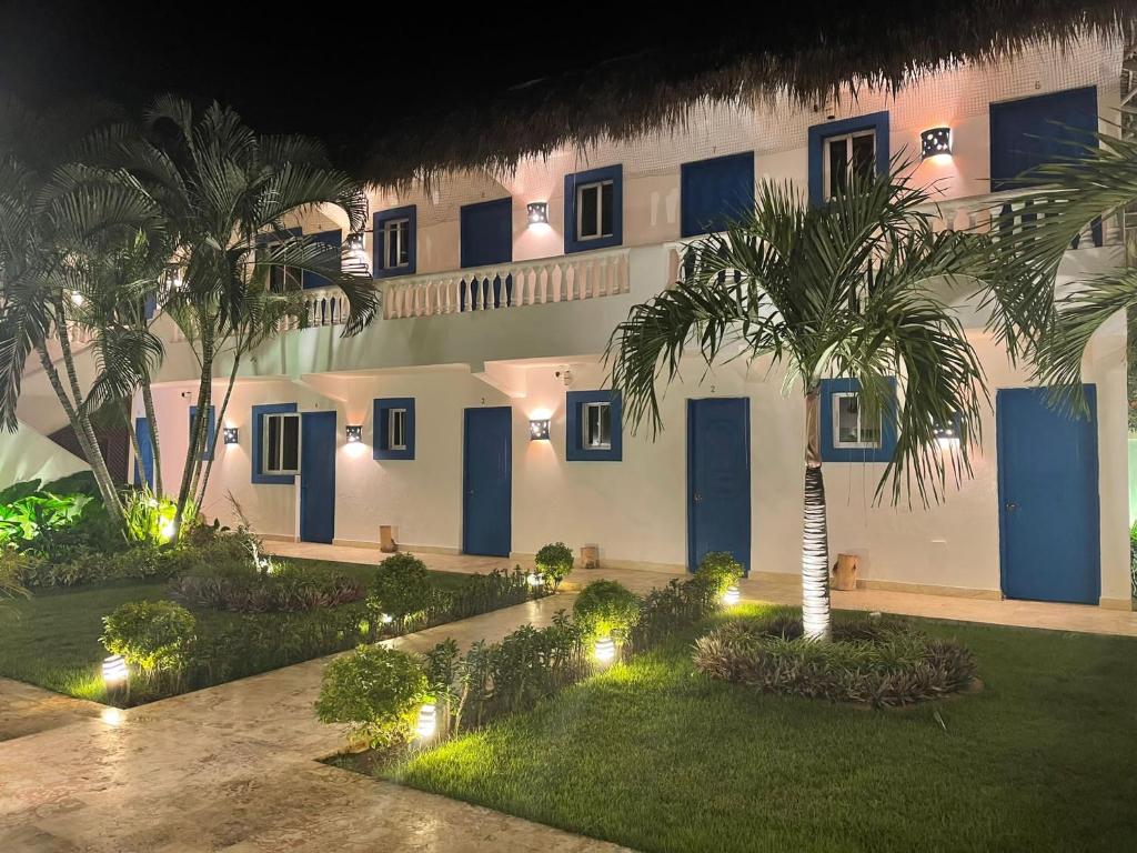 拉罗马纳Nuovo Hotel Playa Catalina的棕榈树和灯的建筑的庭院