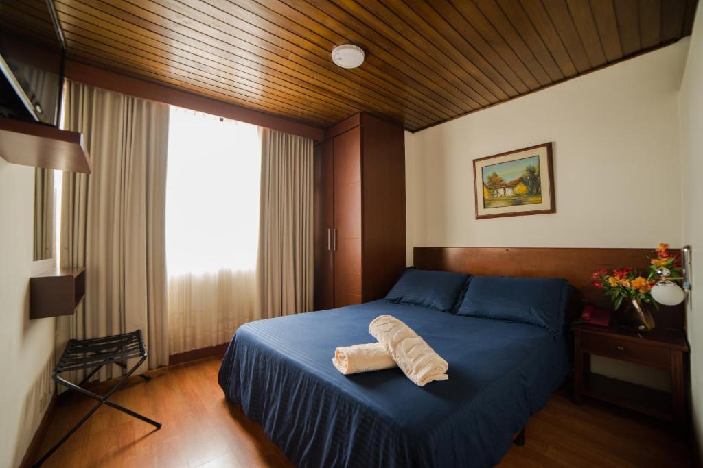 波哥大Apartamentos Galerías的一间卧室配有一张蓝色的床,上面有毛巾