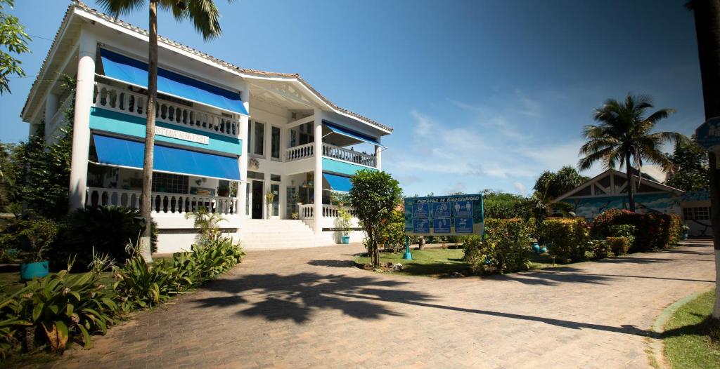 圣安德烈斯阳光海岸宾馆的白色的大建筑,设有蓝色的窗户
