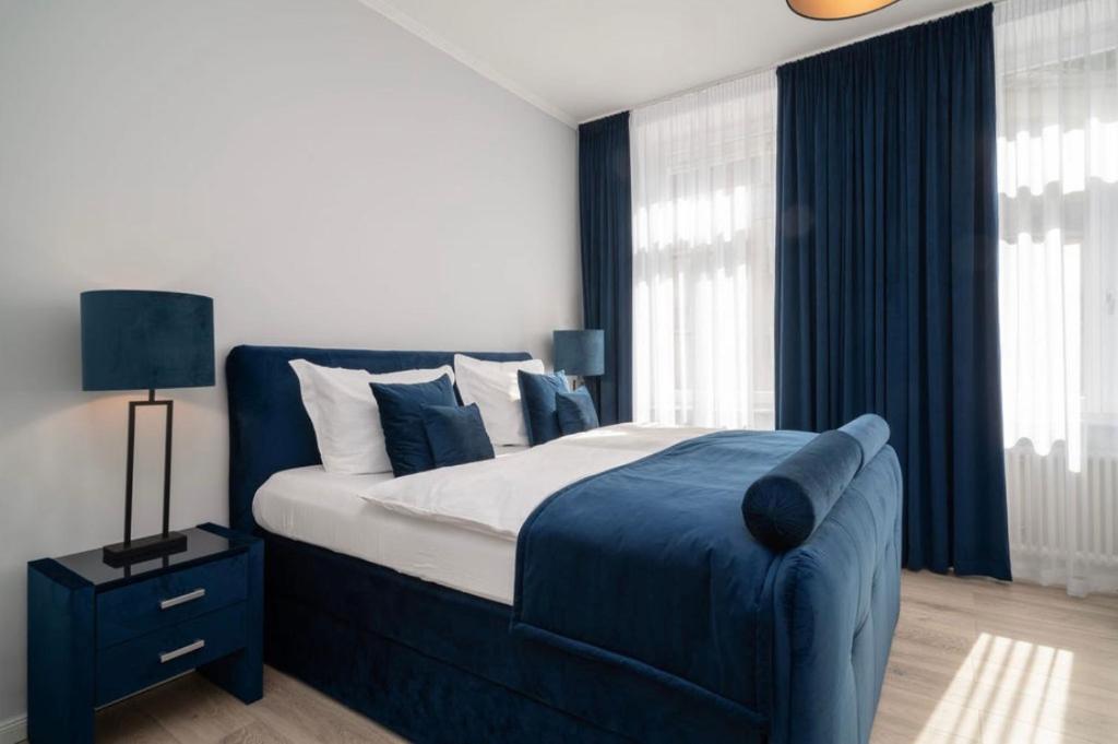 巴登-巴登Blue Sky Apart Center Baden-Baden的卧室设有蓝色和白色的床和窗户。