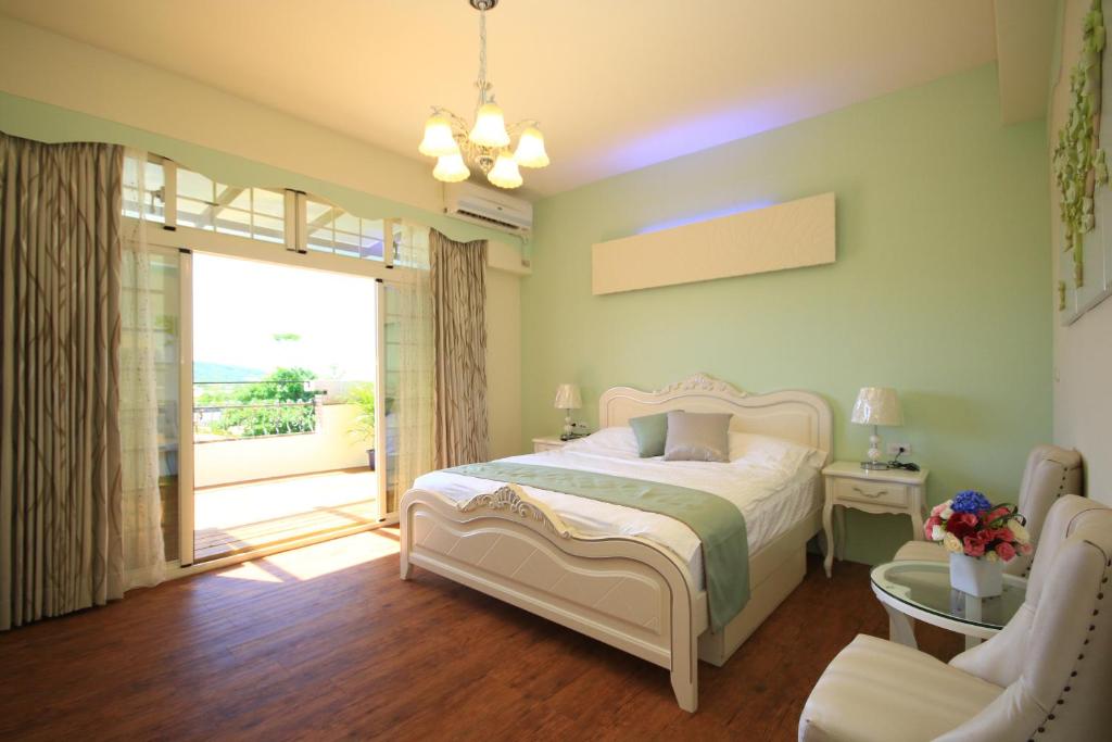 Jiali微风晴园-花莲民宿的一间卧室设有一张床和一个滑动玻璃门