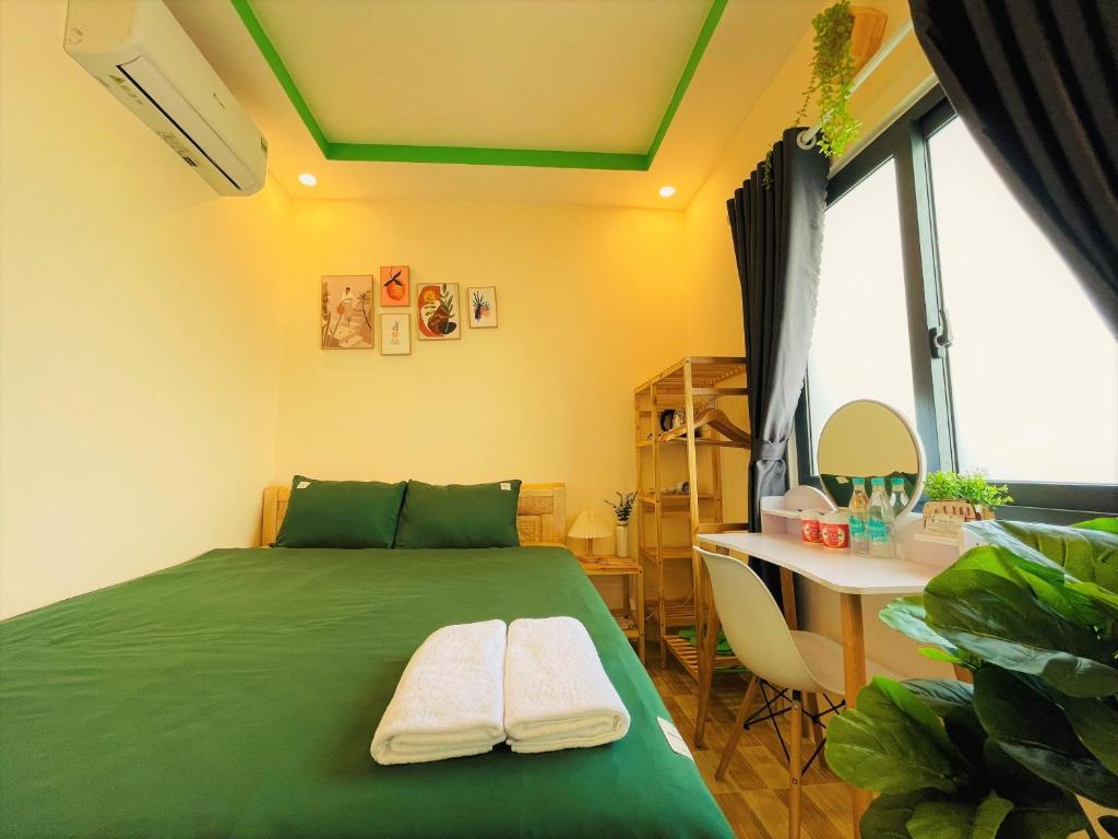 昆岛Duy Cảnh Homestay的一间卧室配有一张绿色的床和一张书桌