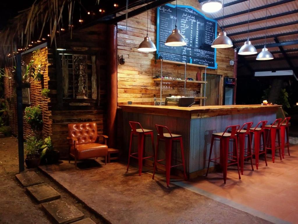 奥南海滩舒适花园度假村的餐厅前的酒吧,有红色凳子