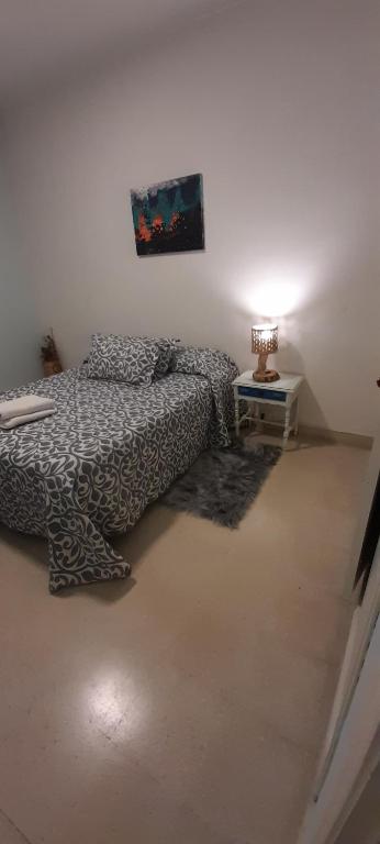 坦迪尔Alquiler Tandil的一间卧室配有一张床和一张带台灯的桌子