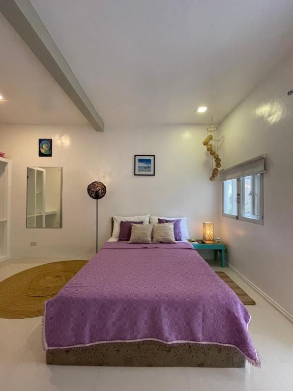 长滩岛Everrich Boutique Resort Boracay的一间卧室,在房间内配有一张紫色的床