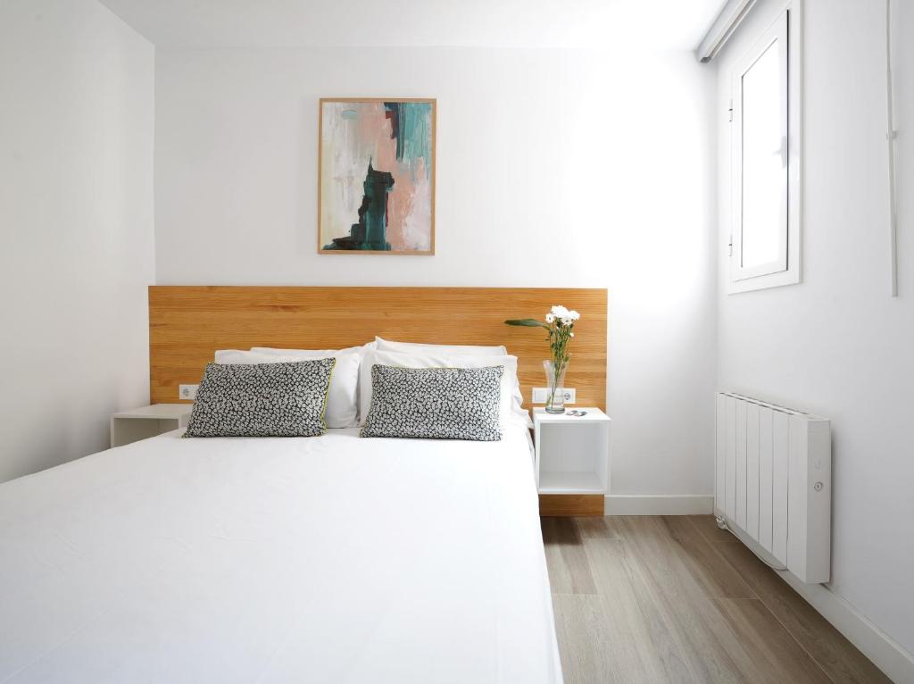 略夫雷加特河畔奥斯皮塔莱特numa I Calid Apartments的白色卧室配有一张大白色床和两个枕头