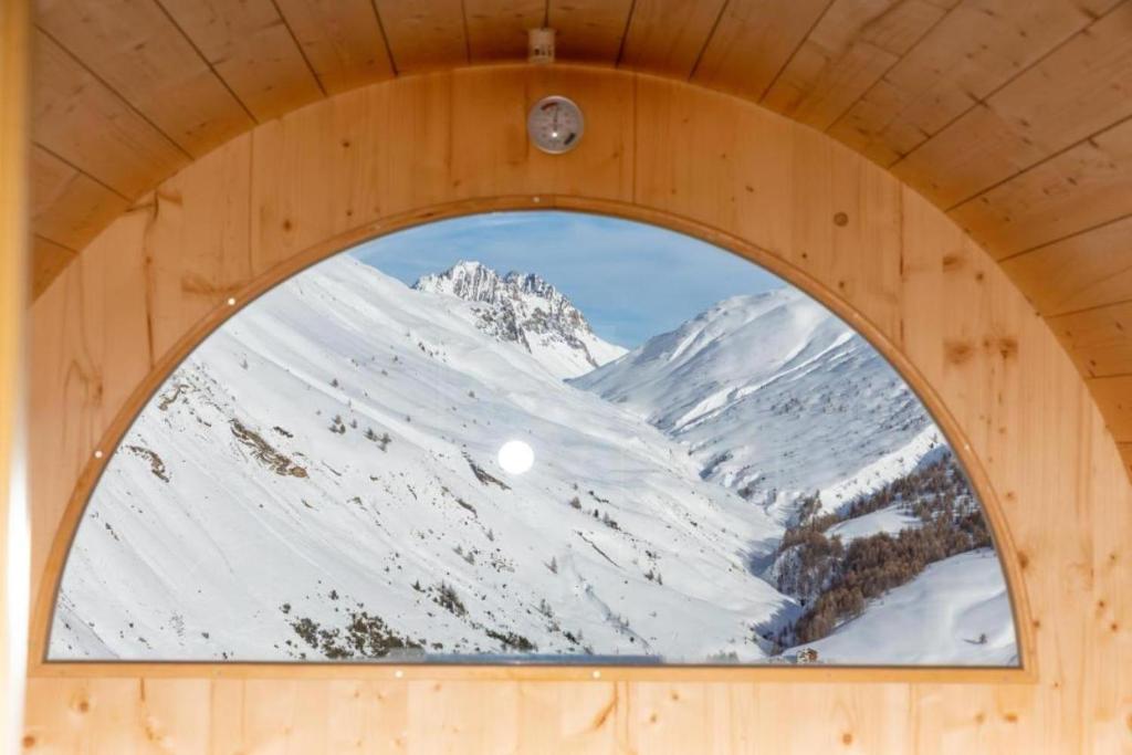 利维尼奥BAITA NOEMI的一座有雪覆盖的山的木制建筑中的窗户