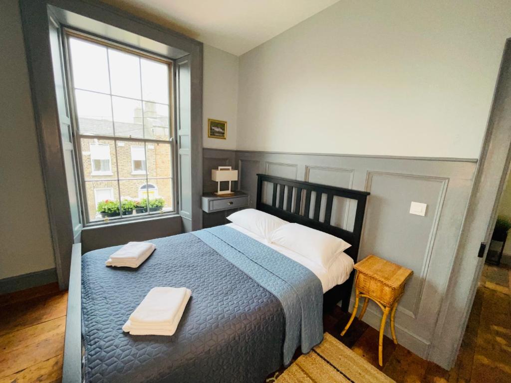 都柏林Old Dublin ‘Four sisters’的一间卧室配有一张床,上面有两条毛巾