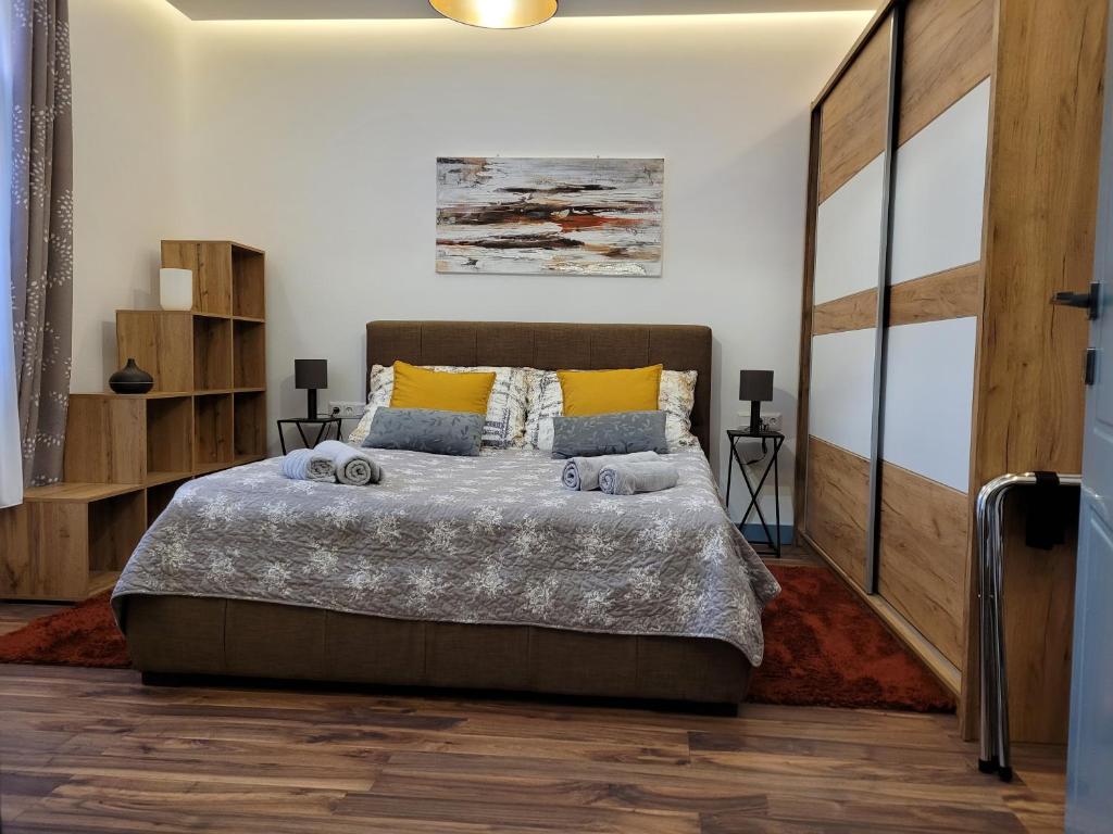 德布勒森Jégmadár Apartman的一间卧室设有一张大床,铺有木地板。