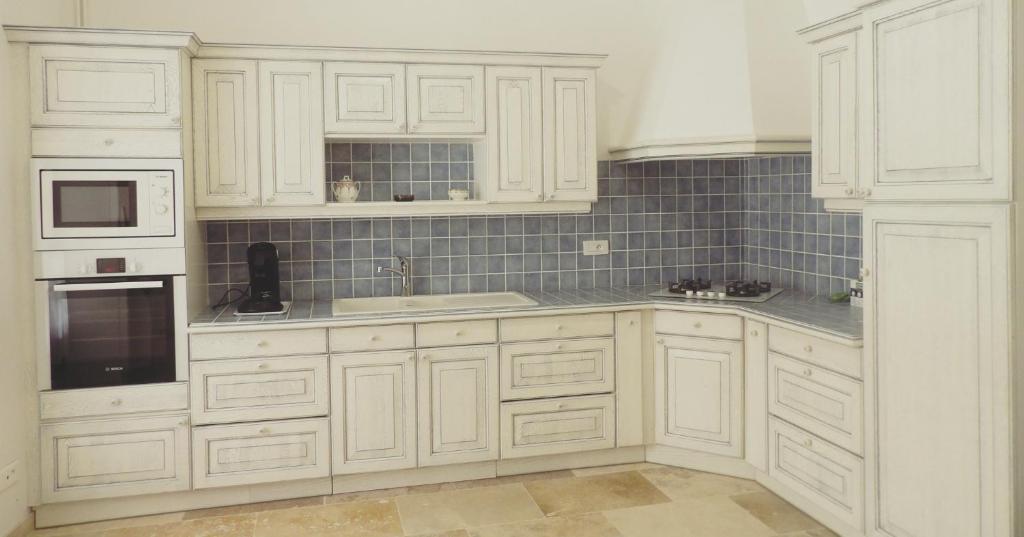 AuvillarGîte Maison Necty的白色的厨房配有白色橱柜和水槽