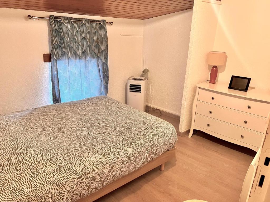 Ruelle-sur-TouvreMaison 2 Chambres - TV - CLIM - BABY FOOT的一间卧室配有一张床、一个梳妆台和一扇窗户。