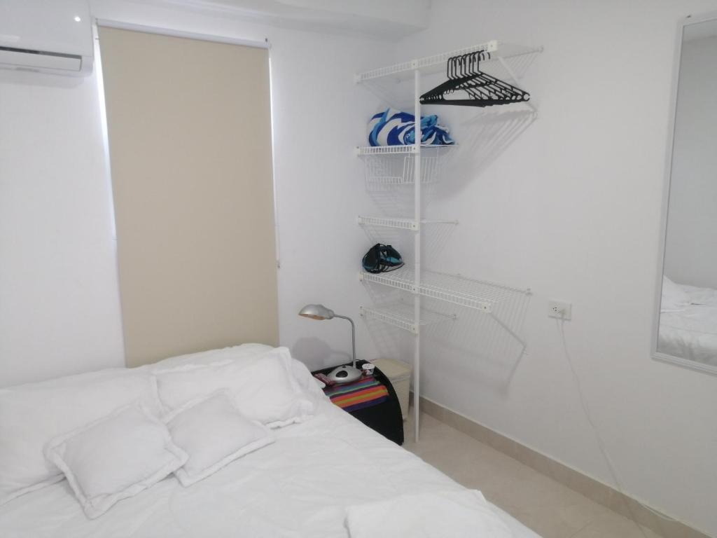 卡塔赫纳Hermoso Apartaestudio, privado, acogedor, super aseado, excelente ubicación!的一间白色卧室,配有一张床和一个衣柜