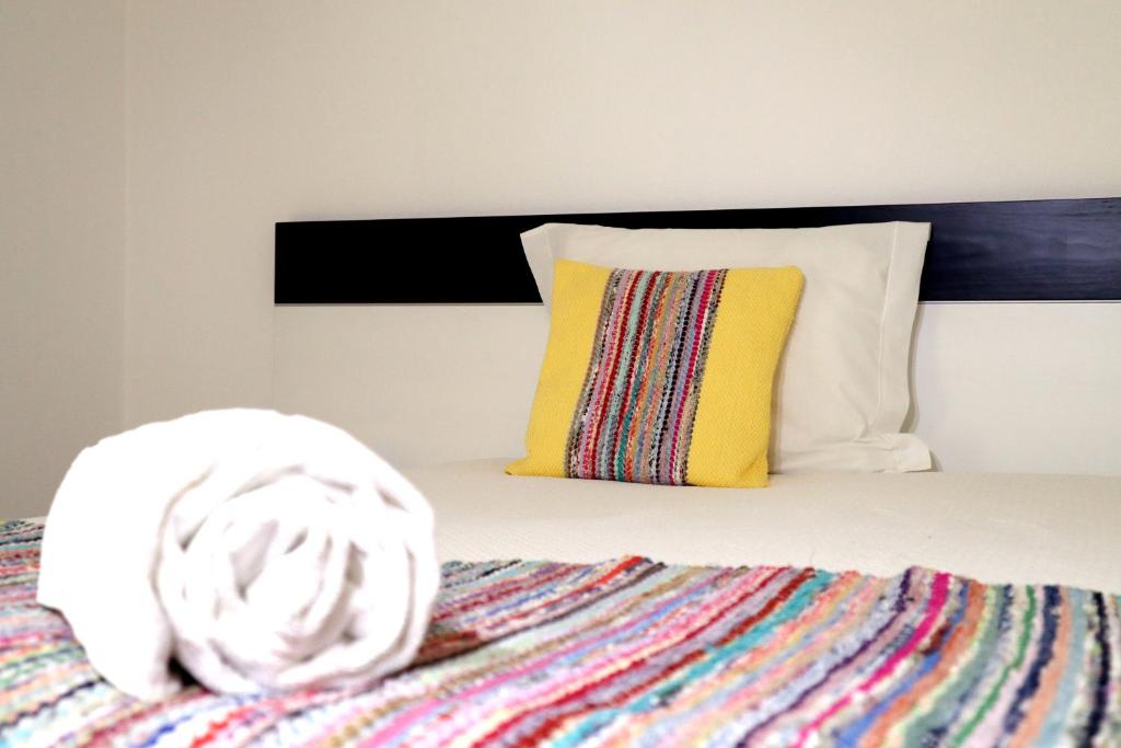 赞布热拉-杜马尔Breathe In的一张带彩色毯子和黄色枕头的床