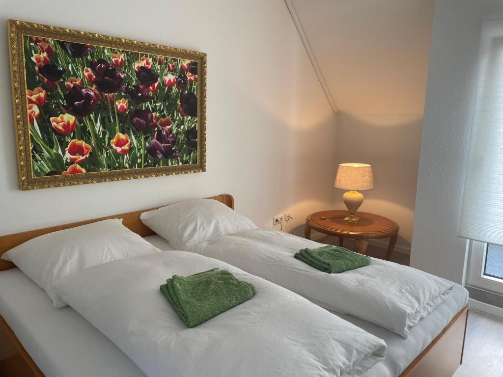 Borgholzhausen2 Zimmer Appartement的卧室内的两张床,墙上有绘画作品