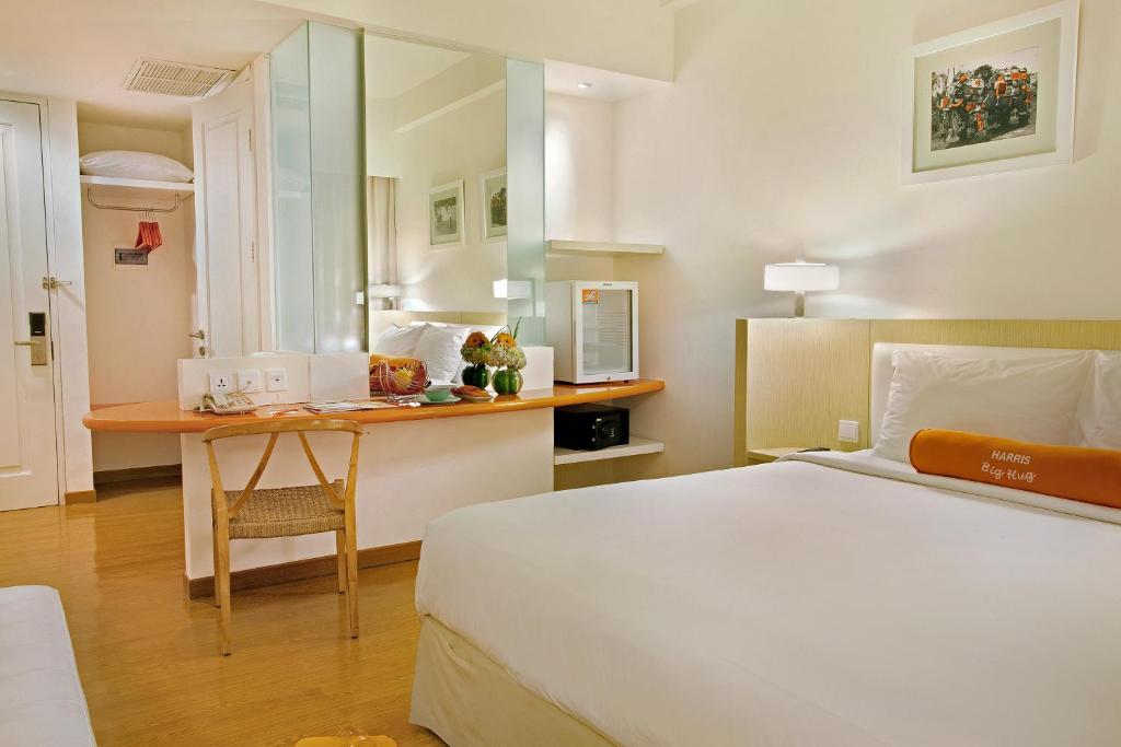 玛琅玛琅哈里斯会议酒店的配有一张床和一张书桌的酒店客房