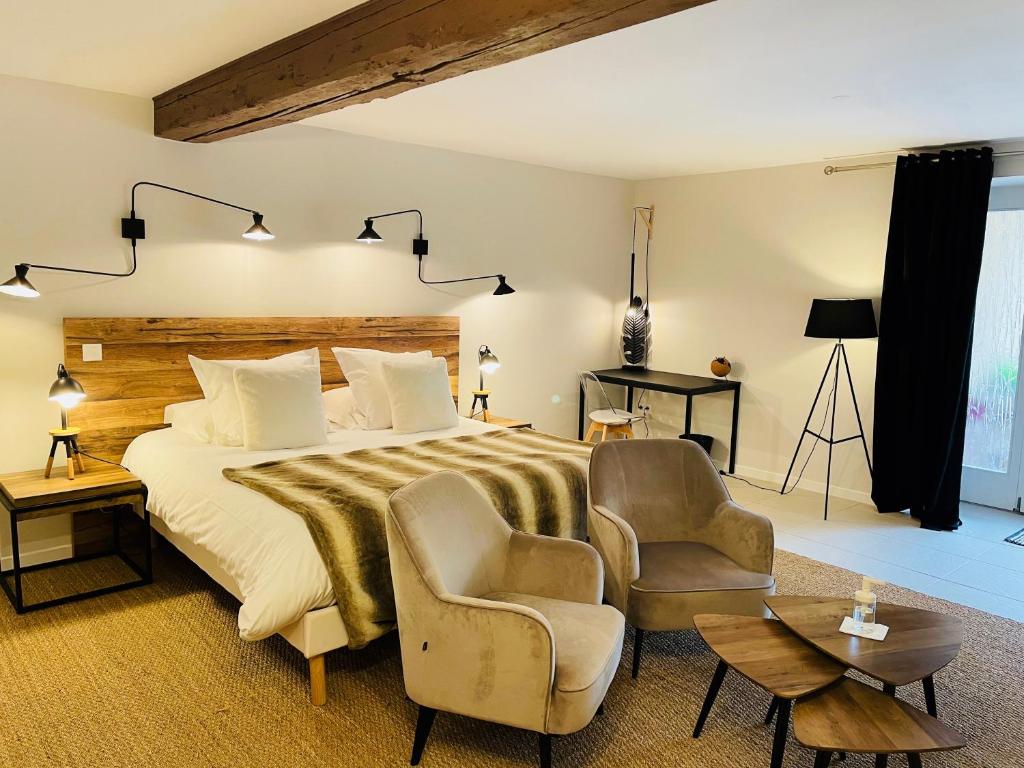 塞莱斯塔Zewwelatreppler - La Grange aux Petits Oignons - Chambre Cigogne的一间卧室配有一张大床和两把椅子