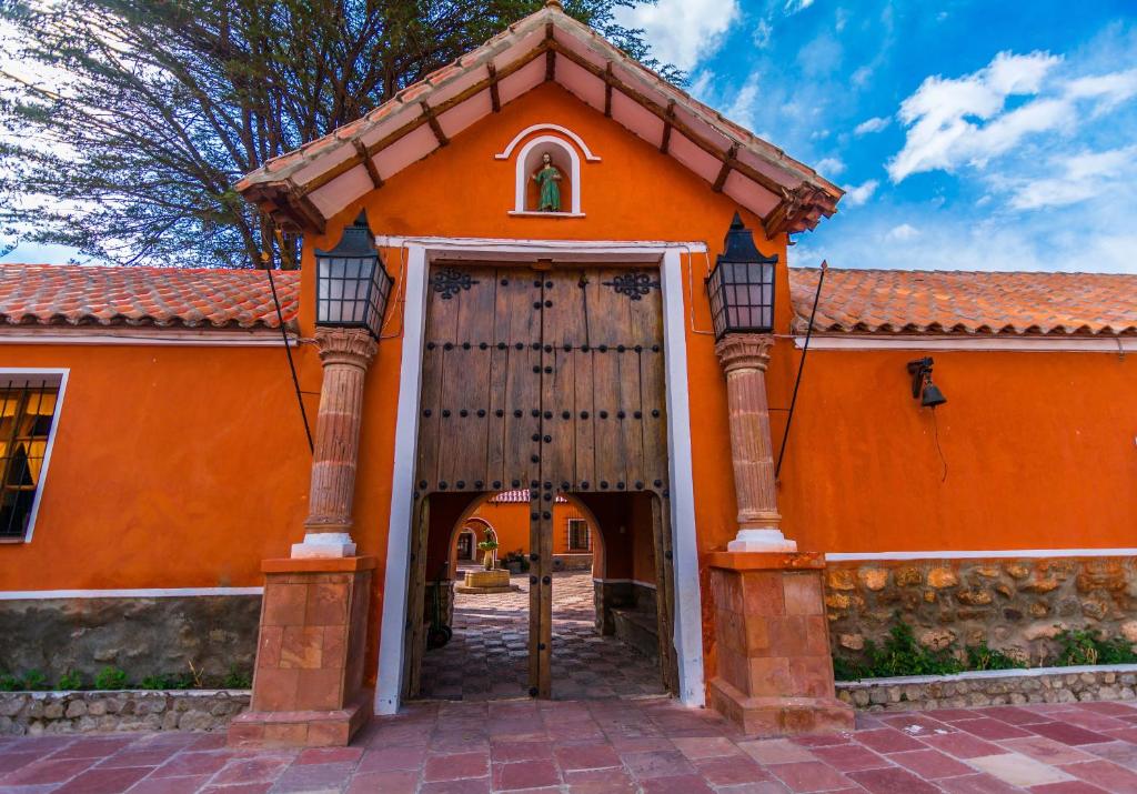 Santa LucíaHotel Museo Cayara的一座橙色的建筑,设有大木门