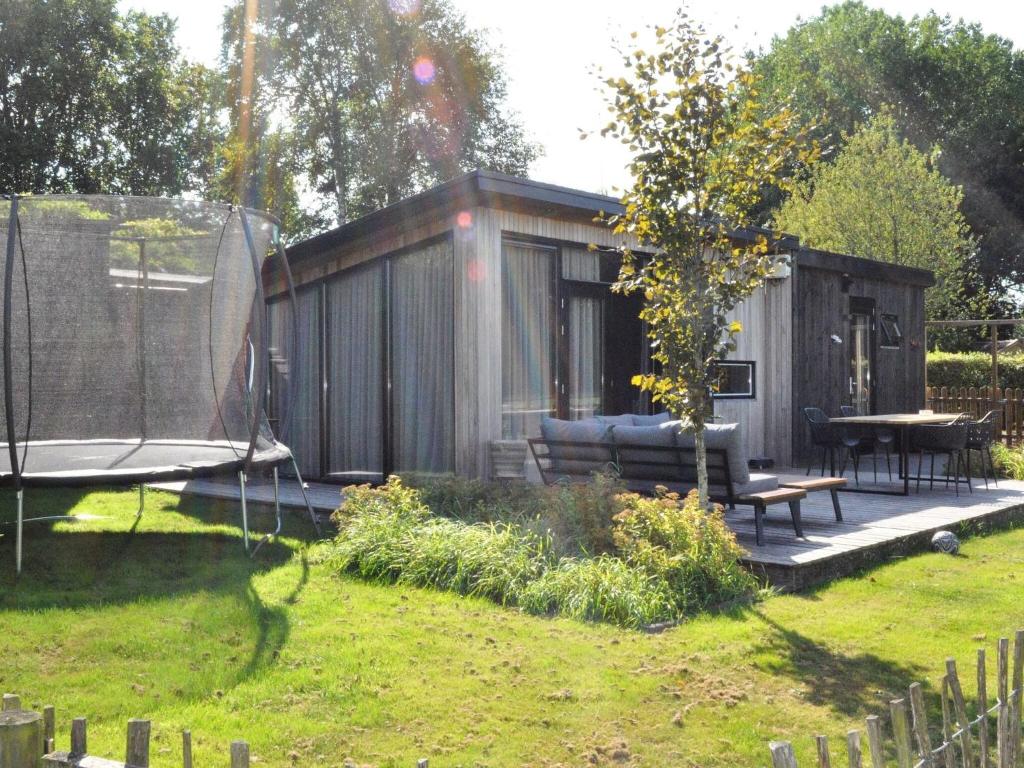 HaulerwijkDetached chalet in Friesland with fenced garden的院子中带长凳和桌子的棚子