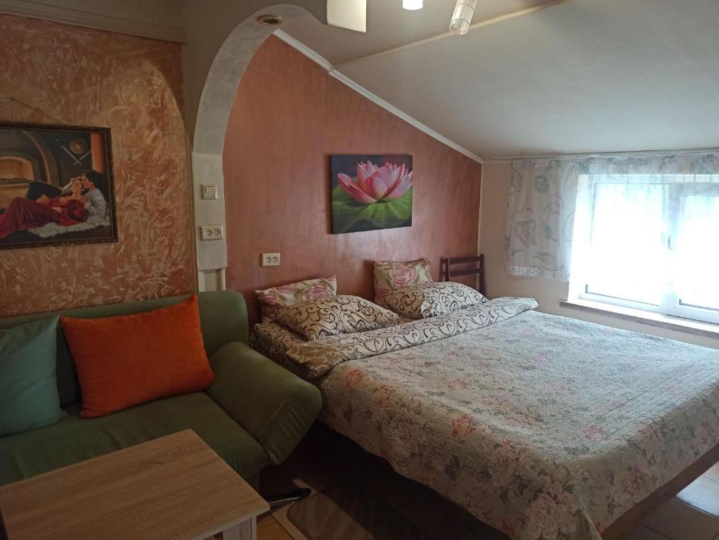 捷尔诺波尔Готель Жасмин的一间卧室配有一张床、一张沙发和一个窗口
