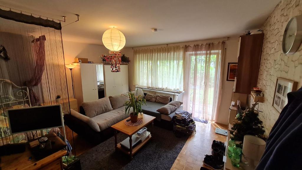 慕尼黑Akropolitan Schönes Zimmer in einer Wohnung mit eigenem großen Garten的带沙发和电视的客厅