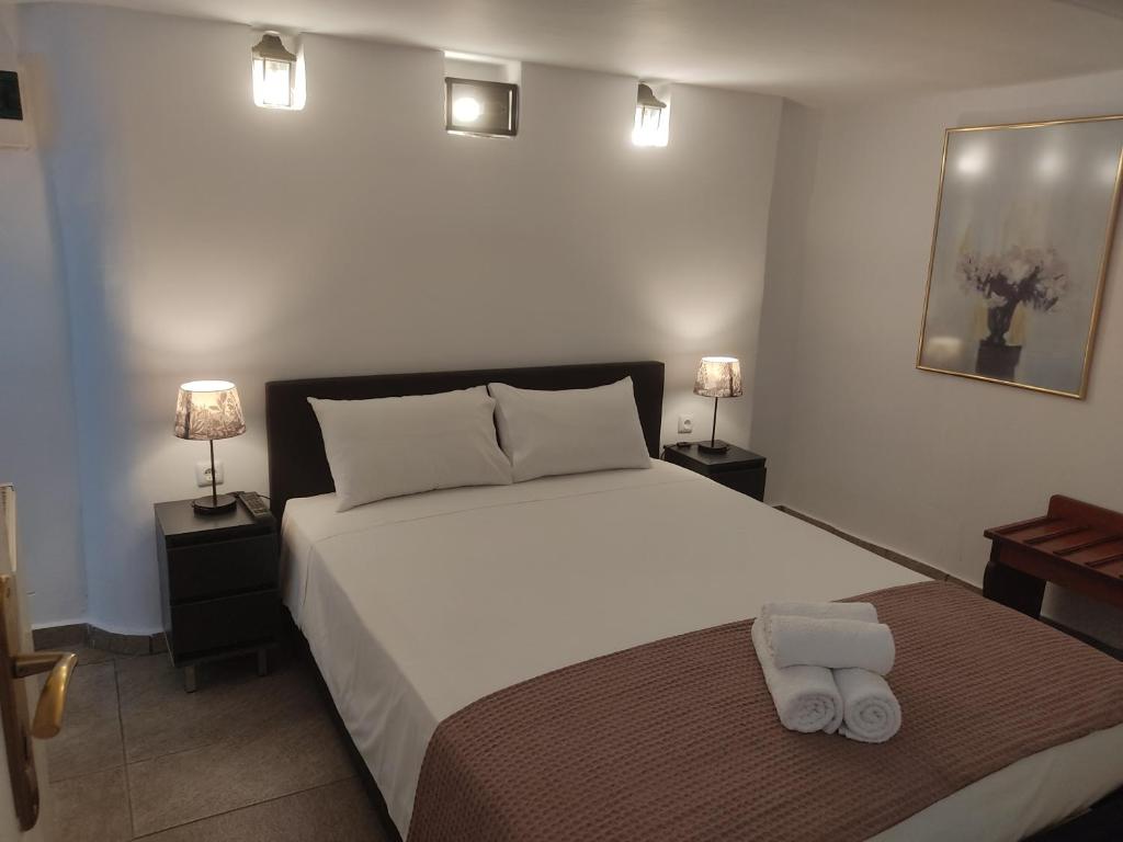 VíliaXenonas ΚITHΑIRON的卧室配有一张白色大床和两盏灯。