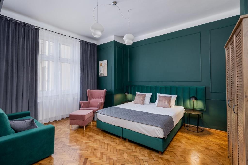 克拉科夫Wawel Boutique Residence - Krakow Old Town的一间卧室设有一张床和绿色的墙壁