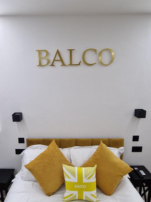 诺丁汉Balco Vista Studio的一张带黄色枕头的床和墙上的标志