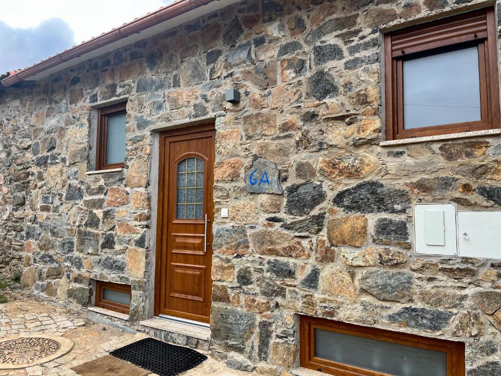 布拉干萨Casa da Barriada II的石屋,设有木门和窗户