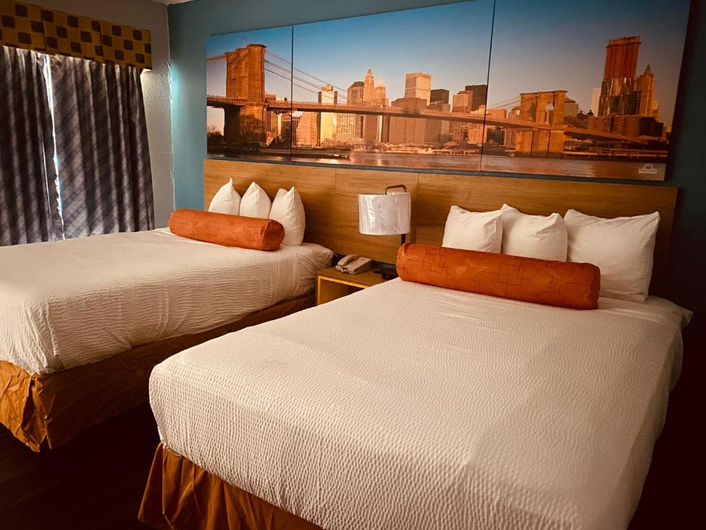 昆斯伯里昆斯伯里戴斯酒店的酒店客房设有两张床,墙上挂有绘画作品