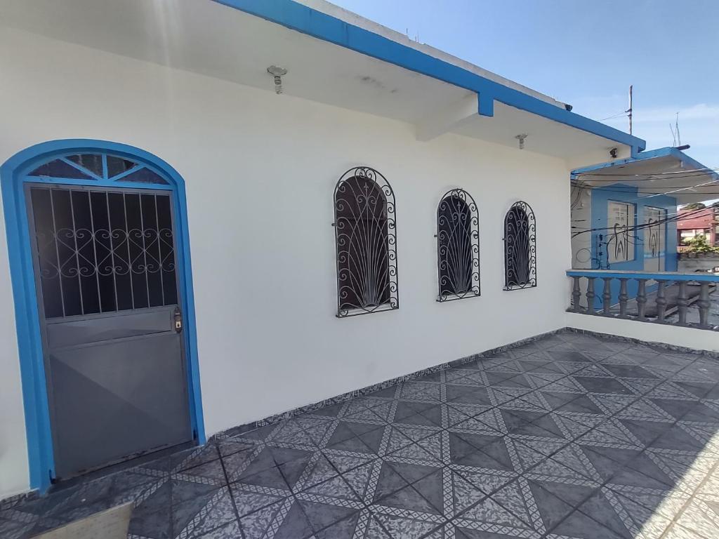 马瑙斯Casa grande em área central, bem iluminada e vent.的白色的建筑,设有蓝色的门和窗户