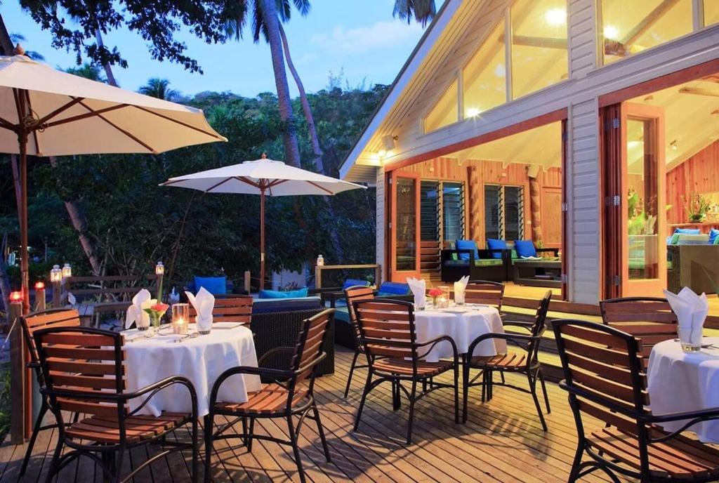 WaiyevoSau Bay Resort & Spa的一间带桌椅和遮阳伞的餐厅