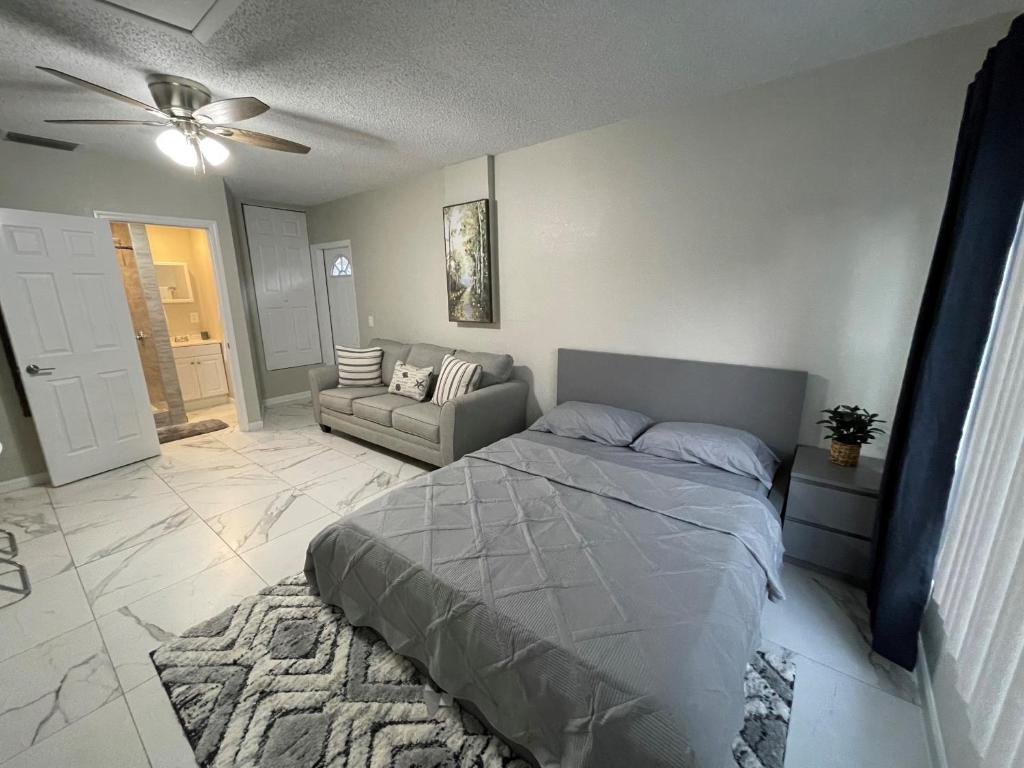 坦帕Adorable Suite in Tampa.的一间卧室配有一张床和一张沙发