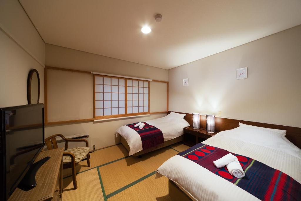 白马村Luna Lodge的酒店客房设有两张床和电视。