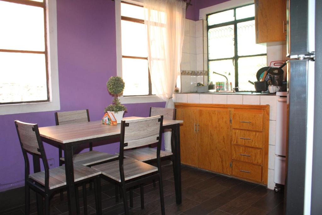 瓜纳华托Casa Jardín的厨房配有桌椅和紫色墙壁