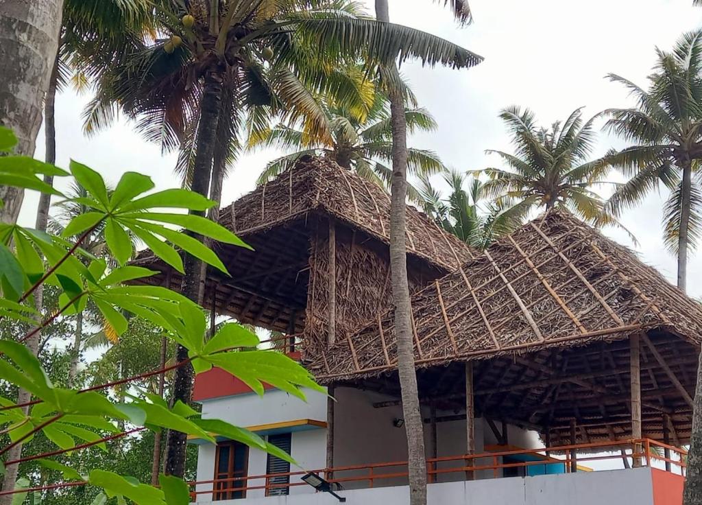 瓦尔卡拉Madhav Mansion Beach Resort的一座正在建造的、有棕榈树的建筑,位于前沿