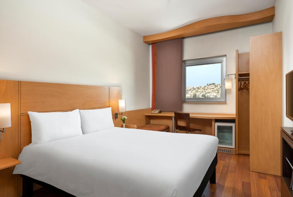 加济安泰普加济安泰普宜必思酒店的卧室配有白色的床、书桌和窗户。