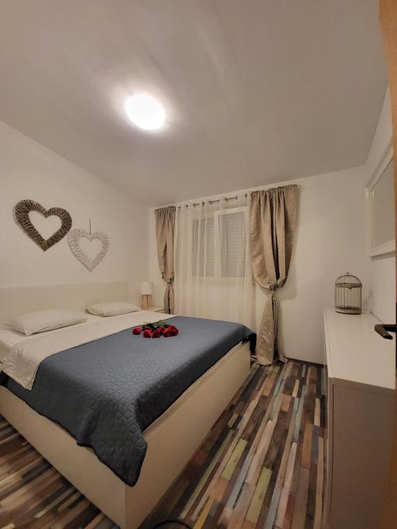 斯拉汀Apartman Roko的卧室配有一张墙上两心床