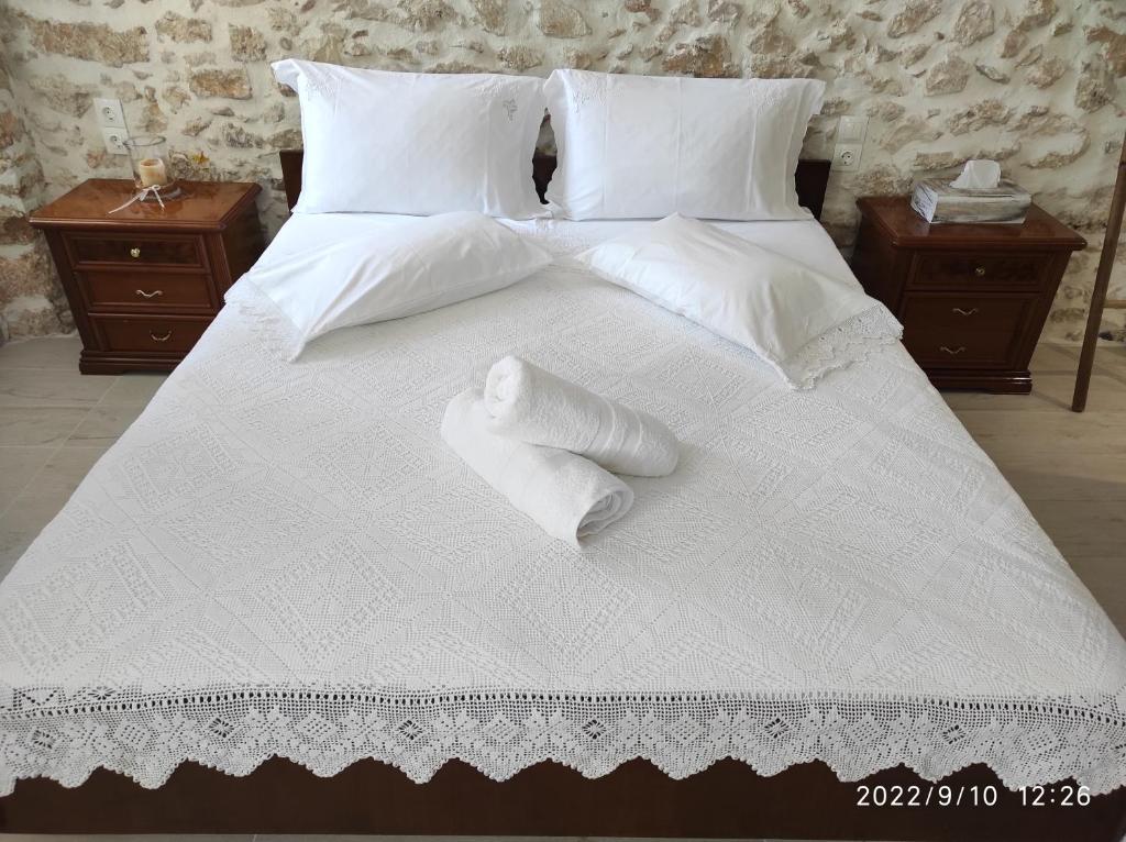 沃丽曼村Xenonas "Alexandra's Coffee House"的一张白色大床,配有白色床单和枕头