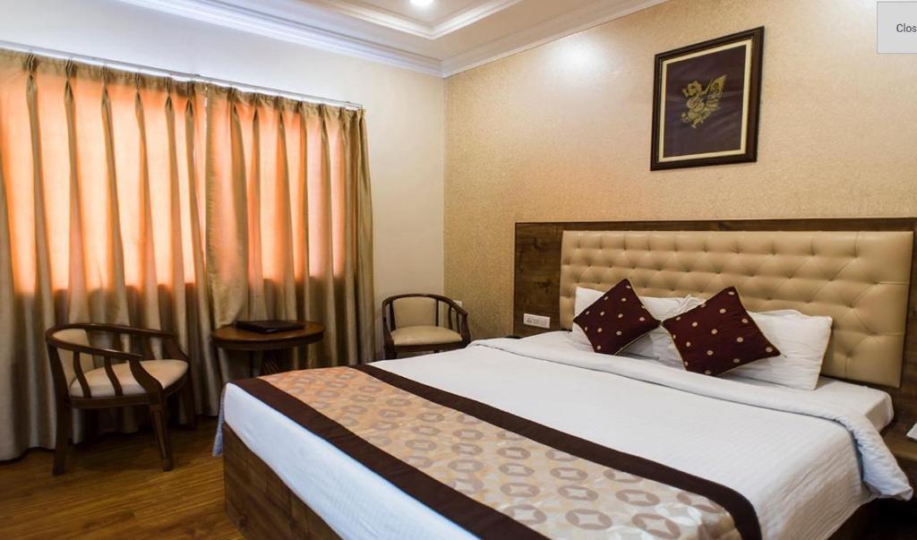 马图拉Wingston A TreeHouse Hotel, Mathura的一间卧室设有一张大床和一个窗户。