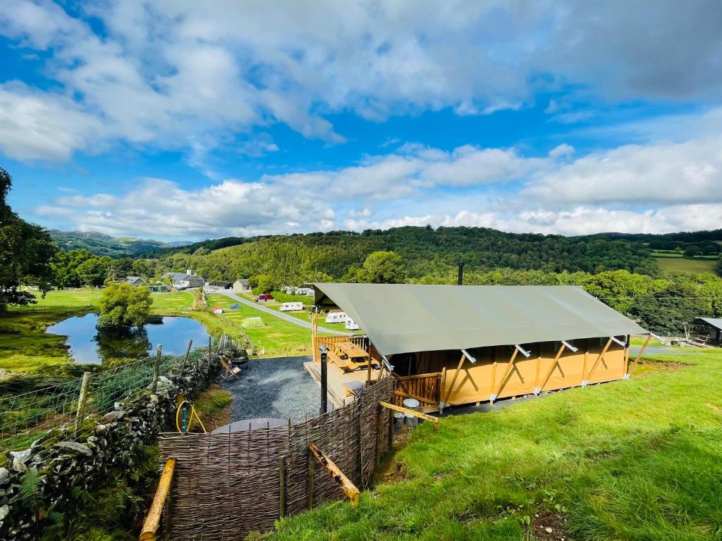 多尔盖罗Quirky Safari Tent with Hot Tub in Heart of Snowdonia的享有一个以河流为背景的凉亭的顶部景色