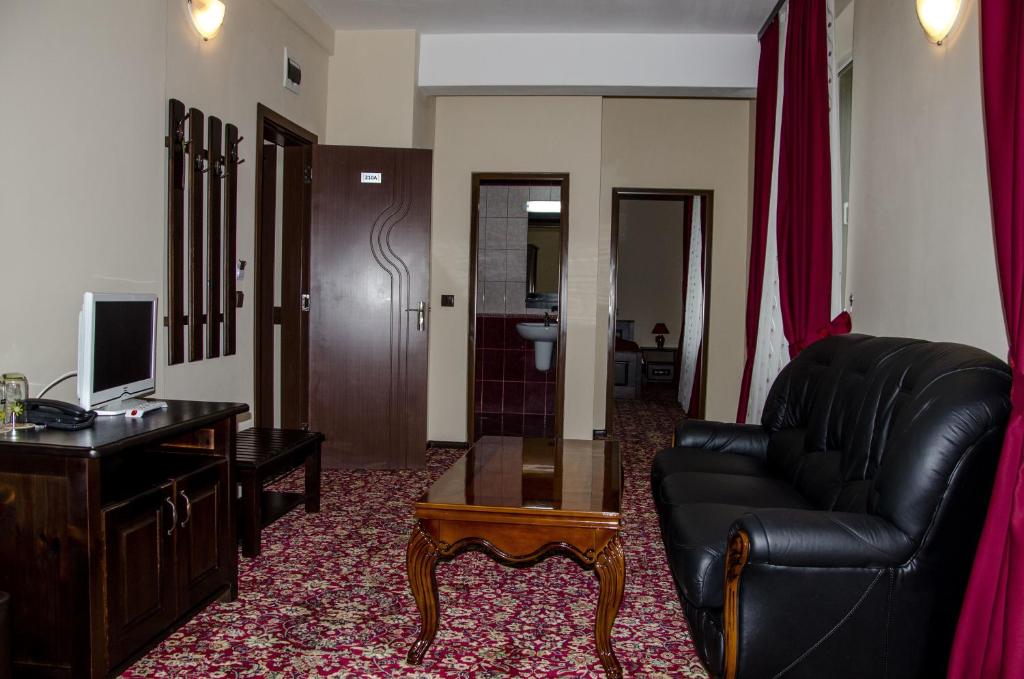 Rudozem红宝石酒店的客厅配有黑色真皮沙发和书桌