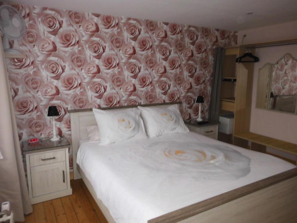 克诺克－海斯特Logies 't Eenvoud (rooms)的卧室配有一张墙上玫瑰床。