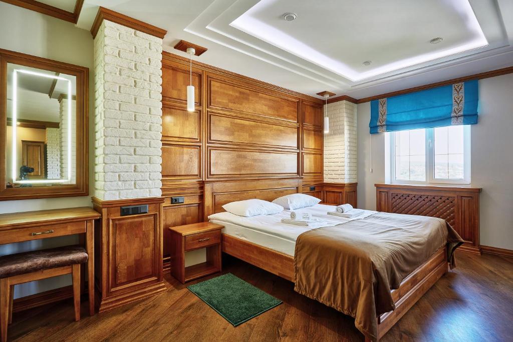 卡缅涅茨-波多利斯基塔拉斯布巴酒店的一间卧室配有一张大床和镜子