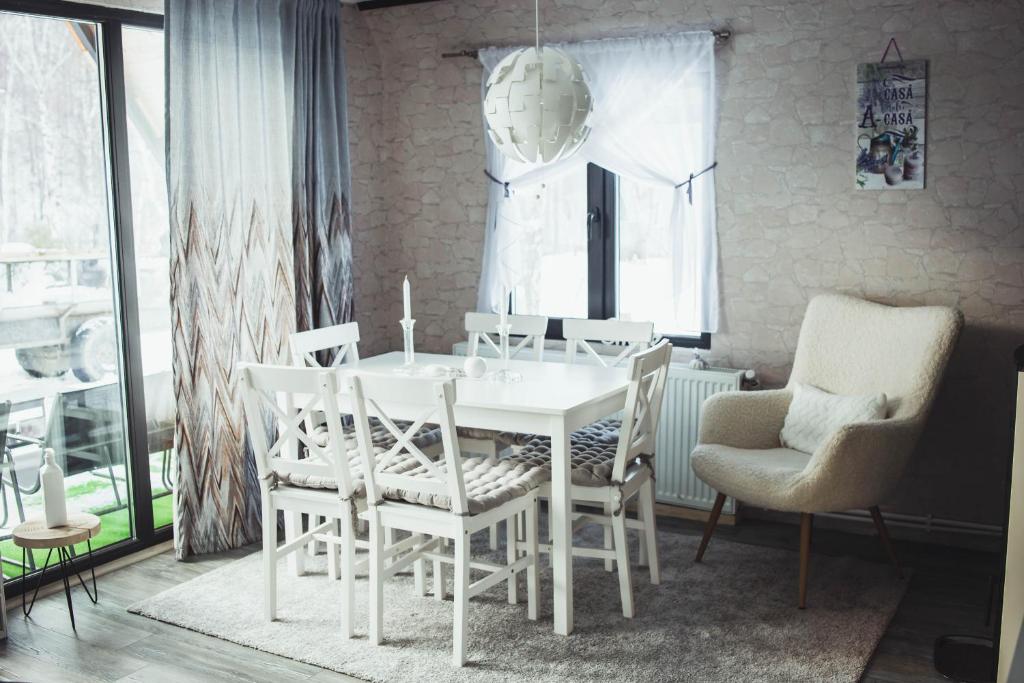LupeniAcasă Straja - Casa Nordică的一间配备有白色桌椅的用餐室