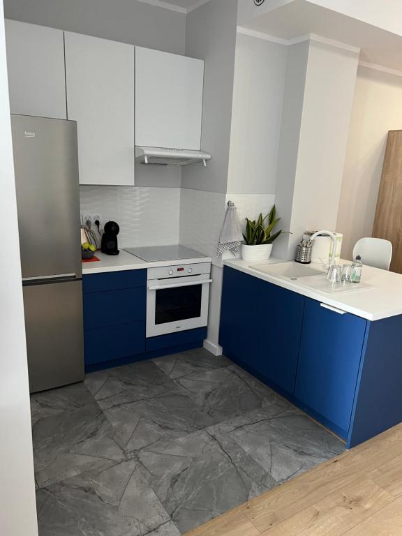 卡托维兹Marcinkowskiego 11 - 2的厨房配有蓝白色橱柜和冰箱。