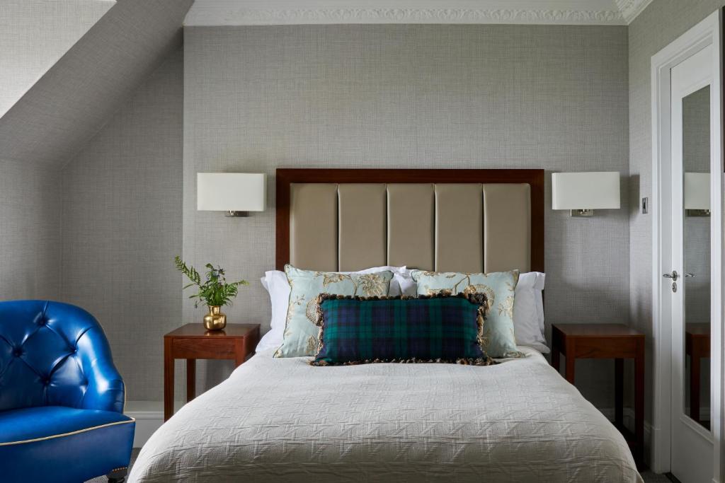 特伦Marine Troon的一间卧室配有一张床和一张蓝色椅子