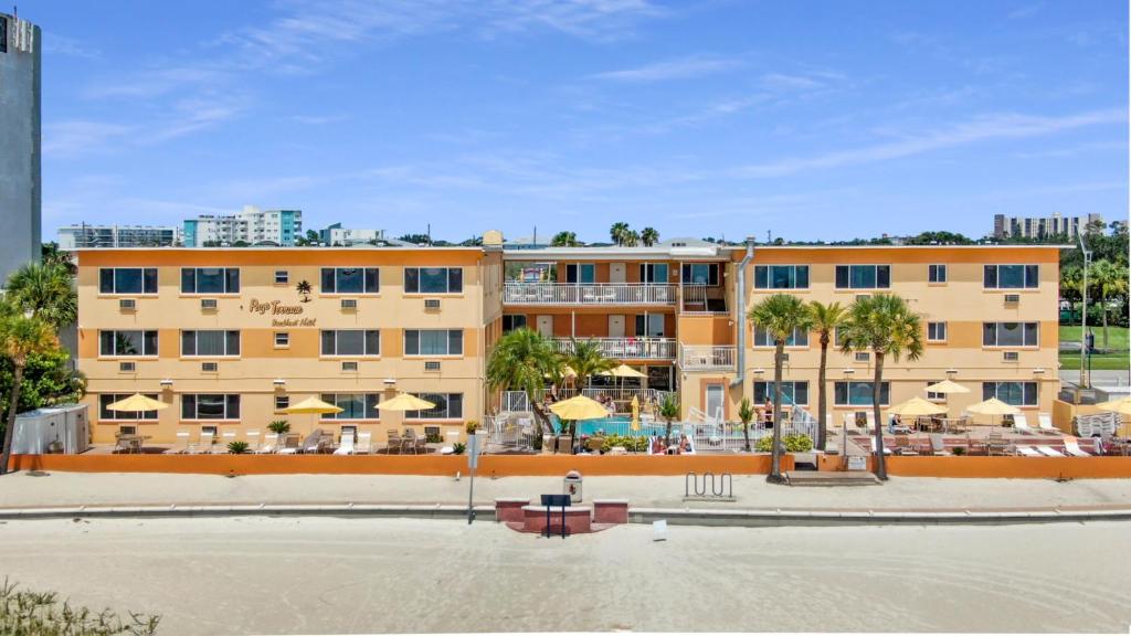 圣徒皮特海滩Page Terrace Beachfront Hotel的一座带游泳池和棕榈树的大型建筑