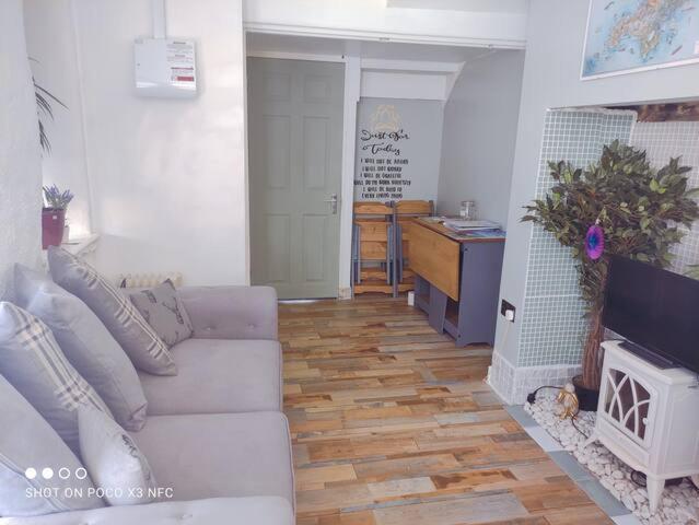 法尔茅斯Cosy Wellbeing Stays on Cornish Coast的客厅配有白色沙发和壁炉
